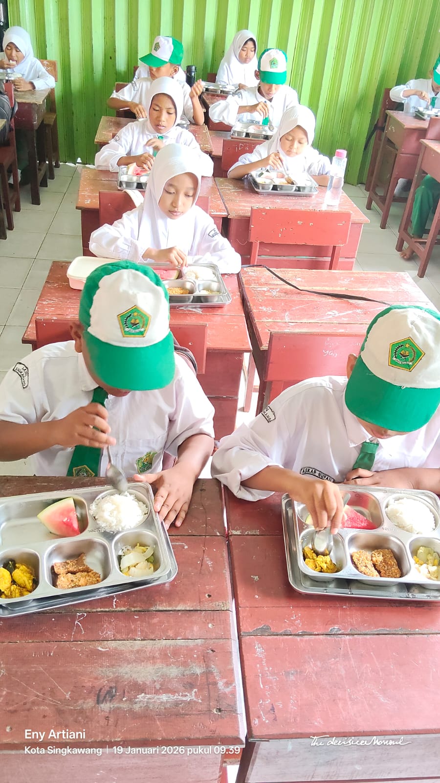 Singkawang, Hari Ini — Program Makanan Bergizi Gratis (MBG) kembali menjadi perhatian hangat di MIN Singkawang. Seperti biasa, seluruh siswa menerima MBG tepat waktu sesuai jadwal distribusi dari dapur madrasah. Kehadiran program ini bukan hanya menjadi bentuk kepedulian guru terhadap kesehatan siswa, tetapi juga menjadi bagian dari pendidikan karakter tentang kebersihan, kedisiplinan, dan rasa syukur. Pada hari ini, MBG yang dibagikan terdiri dari menu sehat bergizi, disiapkan oleh tim guru dan pengelola madrasah. Para siswa terlihat antusias menerima MBG, bahkan beberapa dari mereka menyampaikan bahwa program ini membuat suasana belajar lebih nyaman, karena mereka merasa diperhatikan dan diperkuat secara nutrisi. Kepala MIN Singkawang, Muslimah, S.Pd.I, menyampaikan bahwa program MBG tidak hanya soal makanan, tetapi juga pembiasaan perilaku baik, seperti makan tertib, menjaga kebersihan, serta menghindari pemborosan dan sisa makanan. Menurut beliau, MBG hari ini berjalan lancar dan tertib, dengan seluruh siswa menerima jatahnya